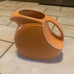Fiesta ware tangerine pitcher. Like new. Retired color.  Large disk pitcher.